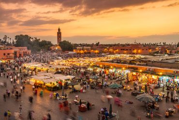 Sunset over Marrakech, Morocco, showcasing vibrant colors illuminating the city's historic architecture and bustling streets in Jamaa Lefna Square is one of the best things to do in Marrakech